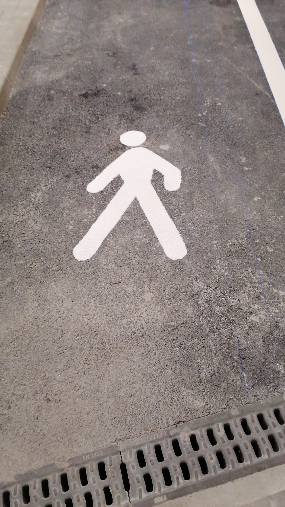 Simbol pietonal aplicat pe asfalt
